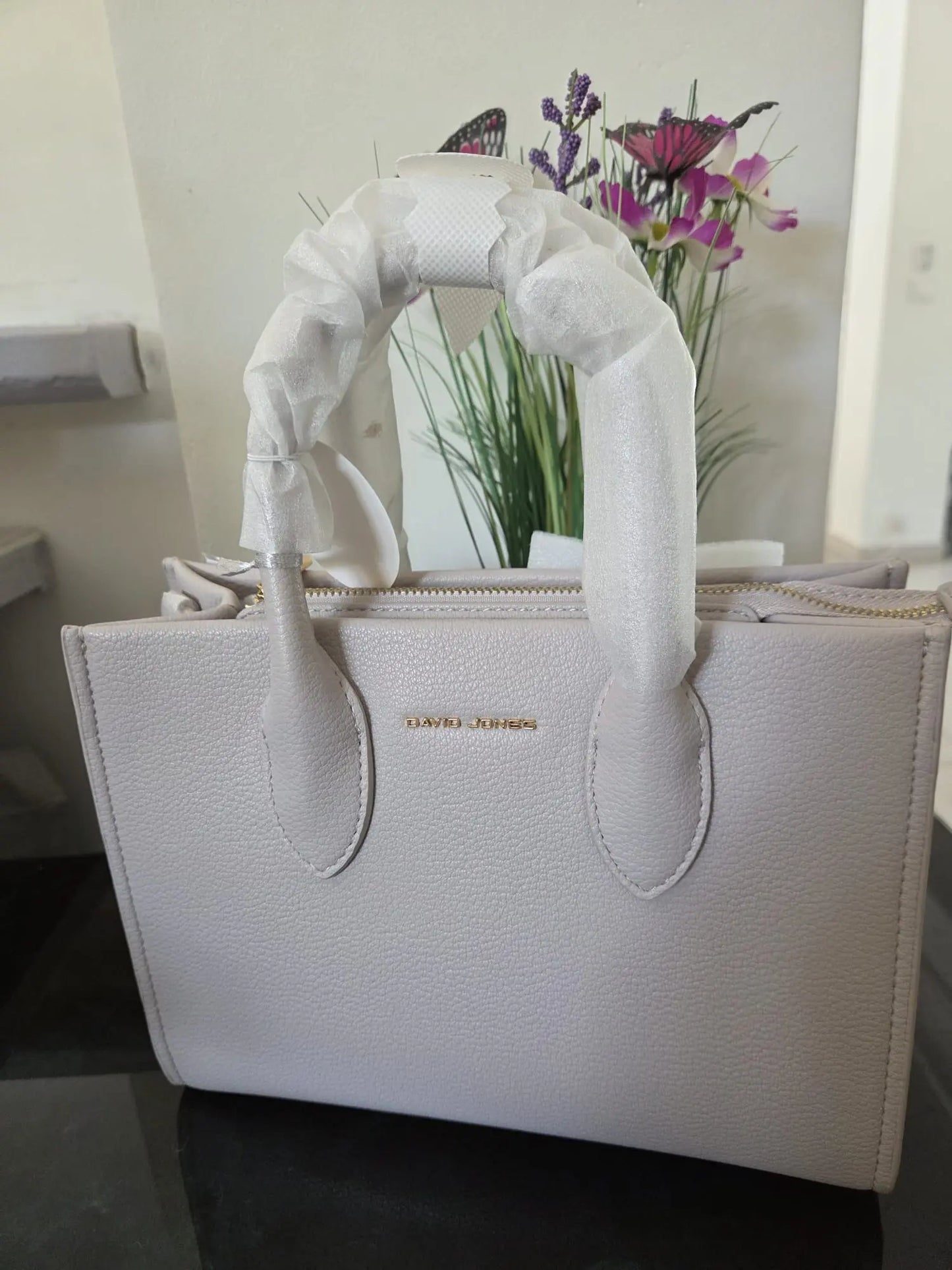 Sac à main élégant David Jones en simili cuir grainé avec fermeture zippée et détails dorés, chic et moderne pour femme.
