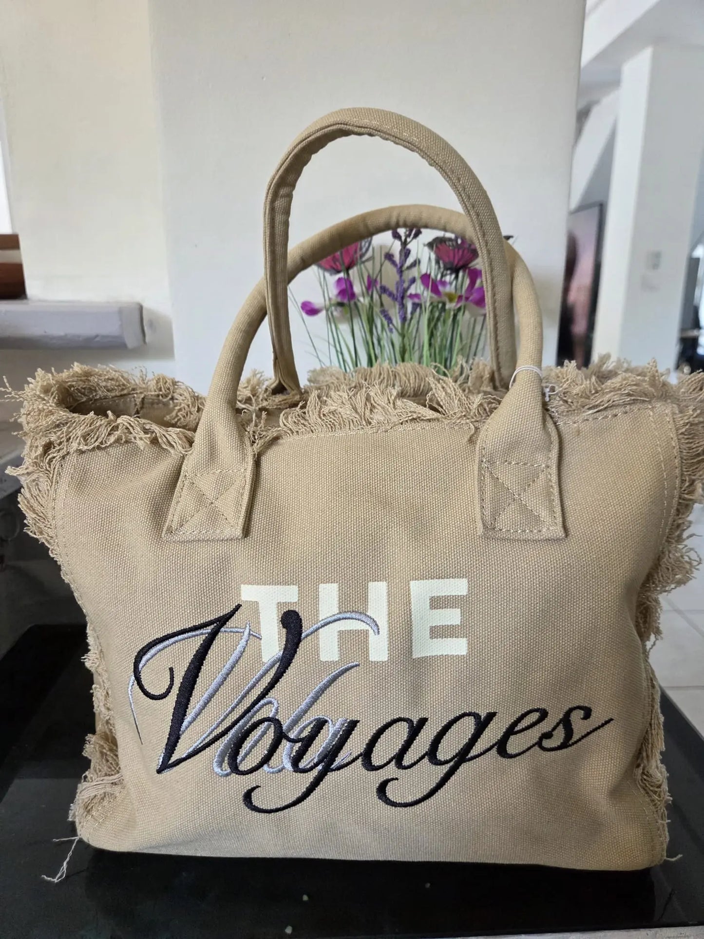 Sac taupe femme à main ou bandoulière avec effet toile de jute, fermeture éclair et multiples poches de rangement.