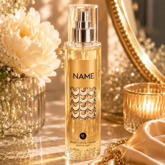 Brume parfumée NAME 200ml pour corps et cheveux dans une ambiance élégante dorée avec fleurs blanches et décoration chic féminine.