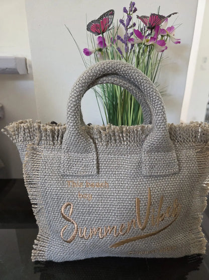 Petit sac femme “Summer Vibes” style bohème chic avec anses rigides, fermeture zip et bandoulière, disponible en plusieurs coloris pour un look estival tendance.
