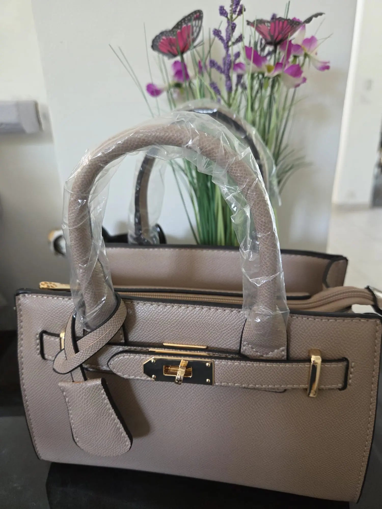 Sac à main élégant en simili cuir grainé avec détails dorés et bandoulière incluse, chic et moderne pour femme.