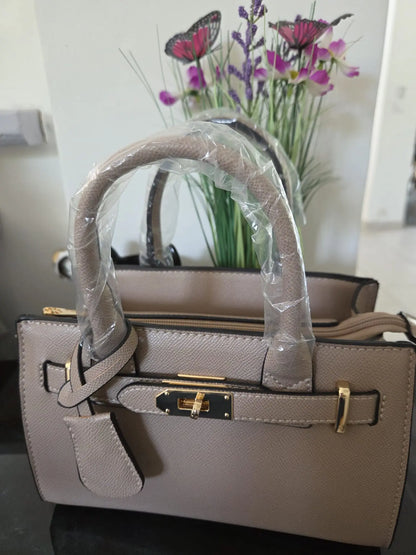 Sac à main élégant en simili cuir grainé avec détails dorés et bandoulière incluse, chic et moderne pour femme.