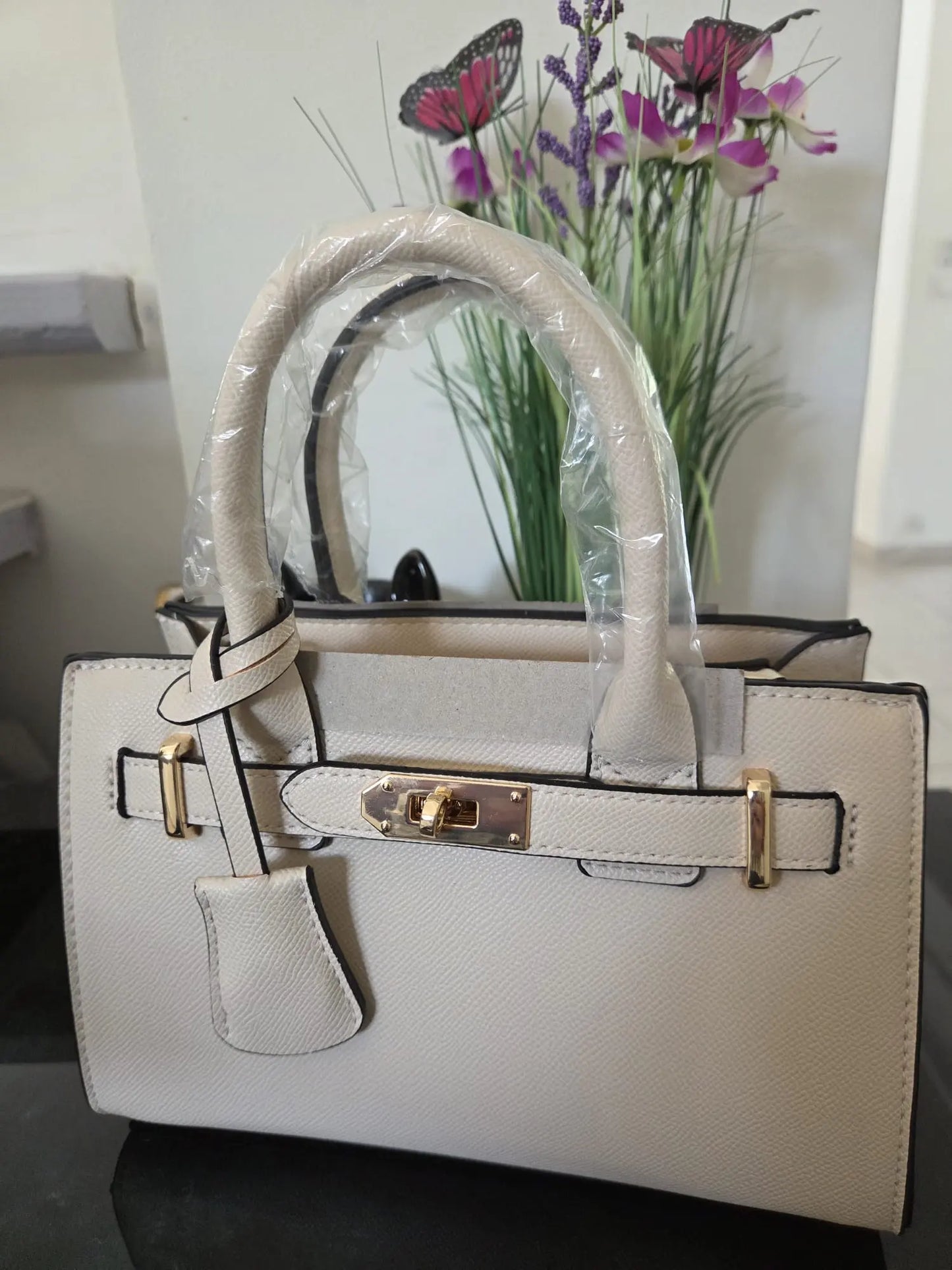 Sac à main élégant en simili cuir grainé avec détails dorés et bandoulière incluse, chic et moderne pour femme.