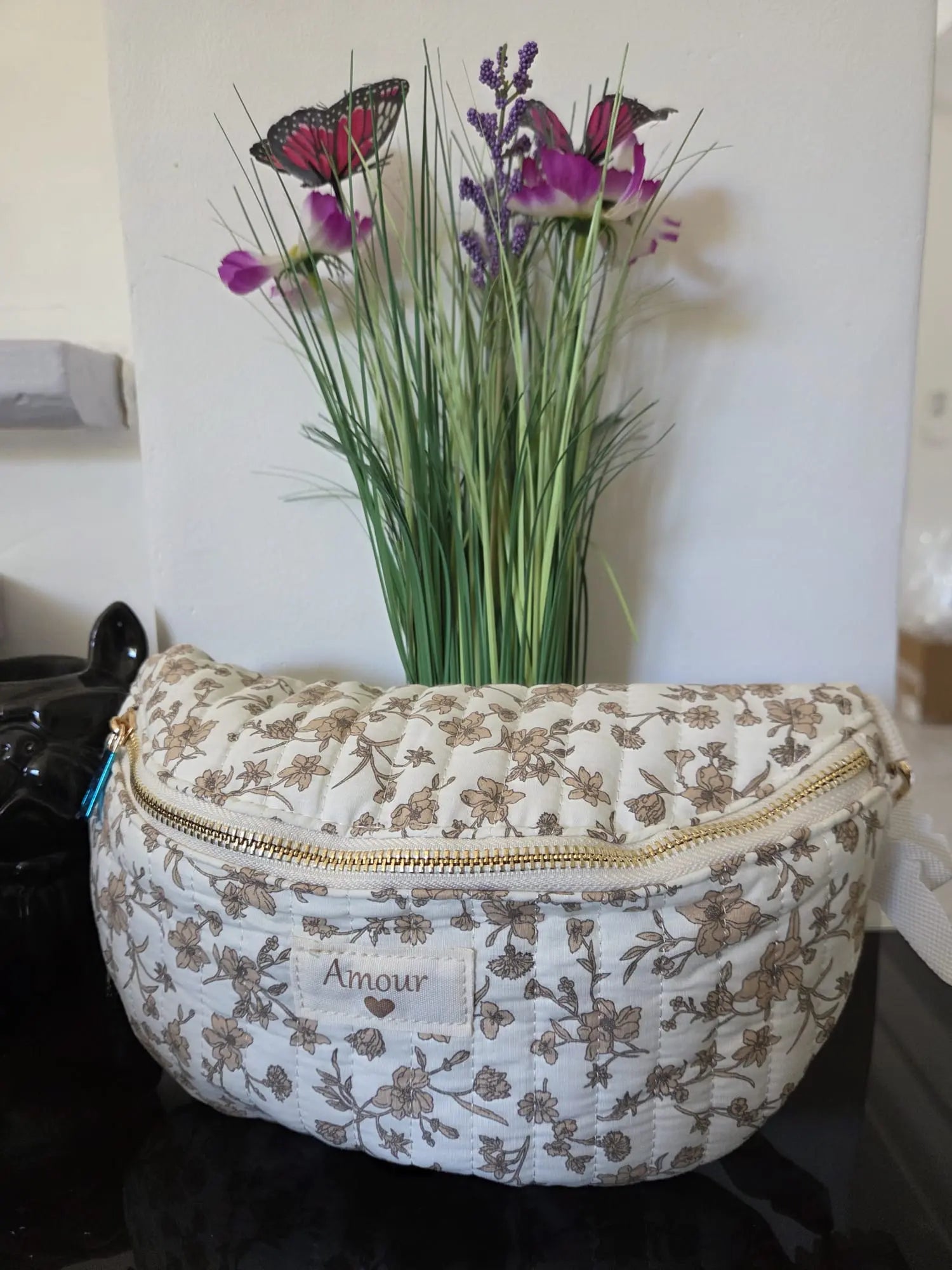 Sac banane matelassé femme motif floral Amour avec fermeture zip et bandoulière réglable.