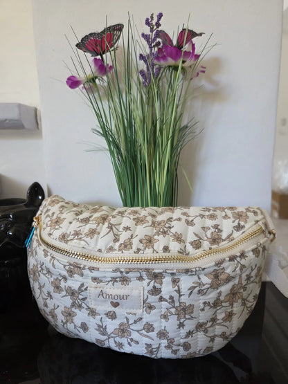 Sac banane matelassé femme motif floral Amour avec fermeture zip et bandoulière réglable.