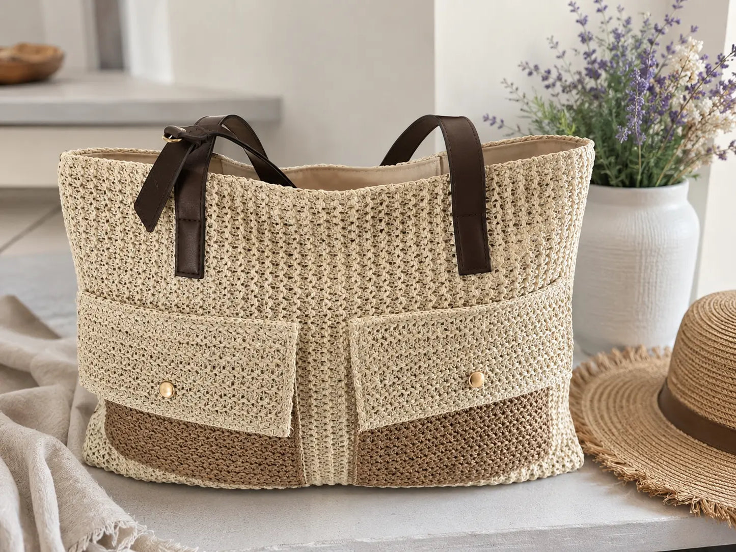 Grand sac cabas bohème en paille tressée avec fermeture zippée, deux poches avant et anses marron, style naturel chic pour l’été et la plage.