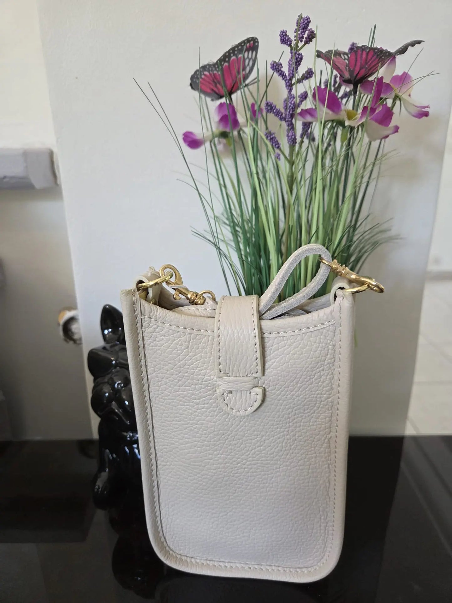 Mini sac téléphone taupe en cuir grainé avec fermeture à pression et détails dorés, élégant et compact pour femme.