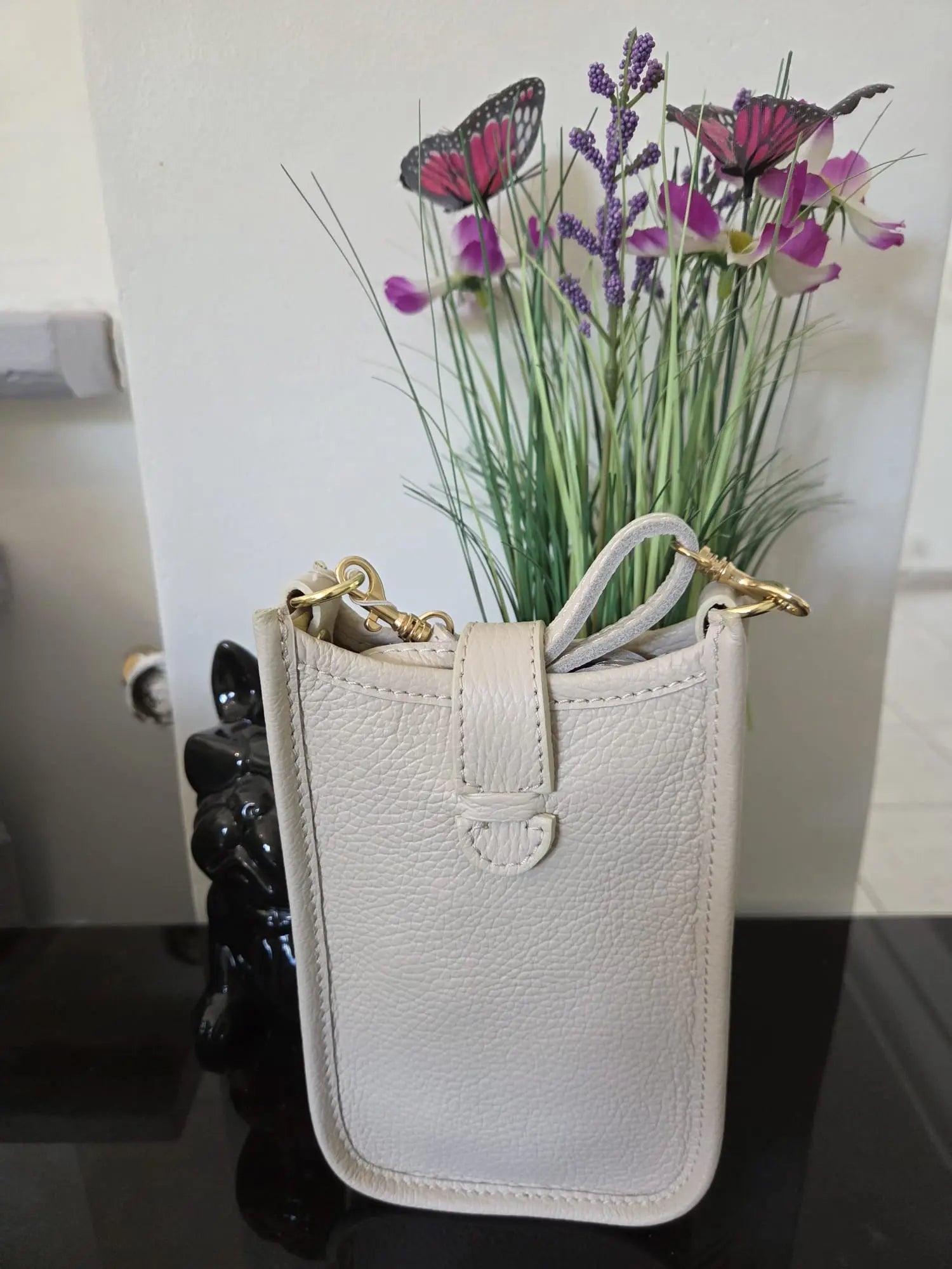 Mini sac téléphone taupe en cuir grainé avec fermeture à pression et détails dorés, élégant et compact pour femme.